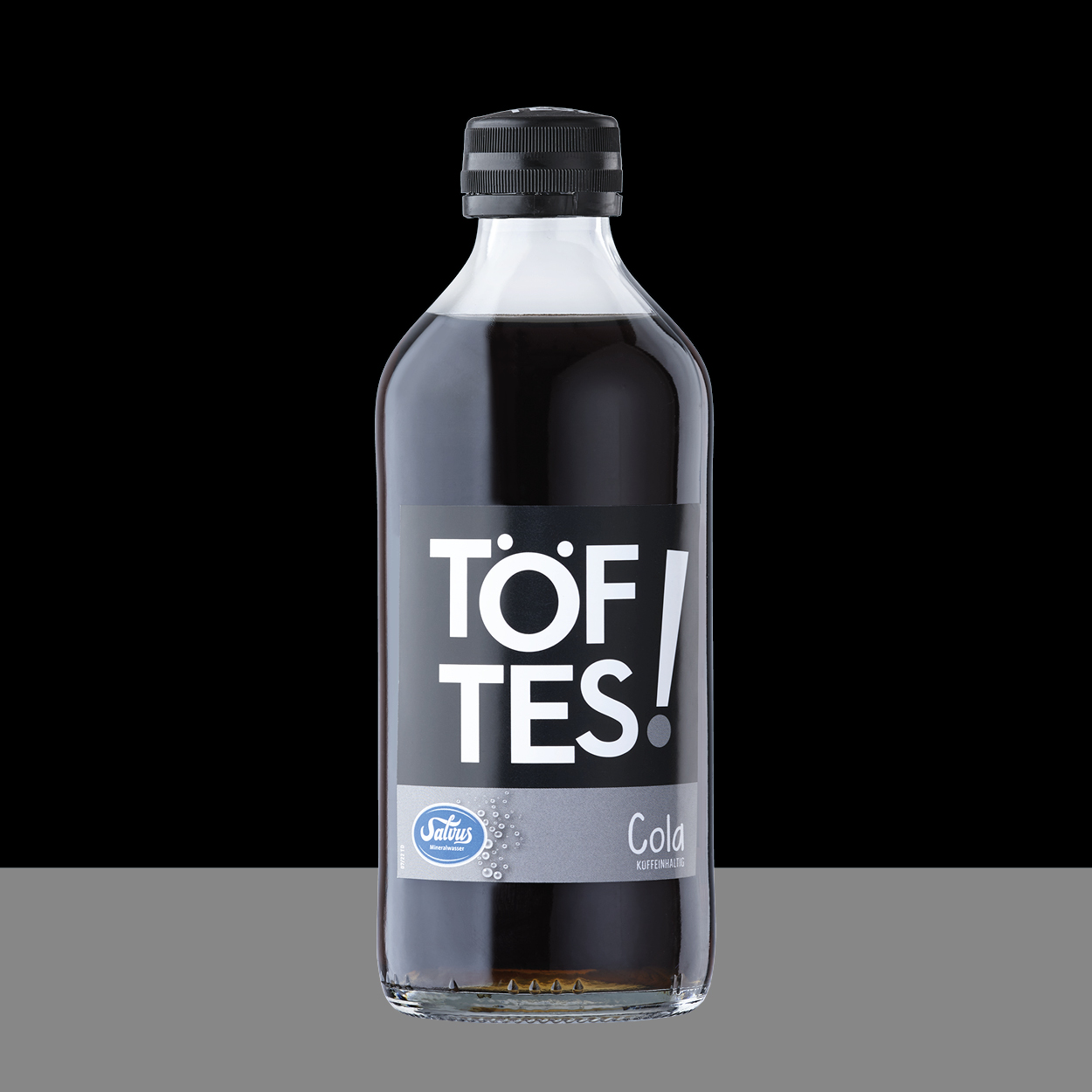 Töftes! Cola auf schwarzem Hintergrund passend zum Etikett.