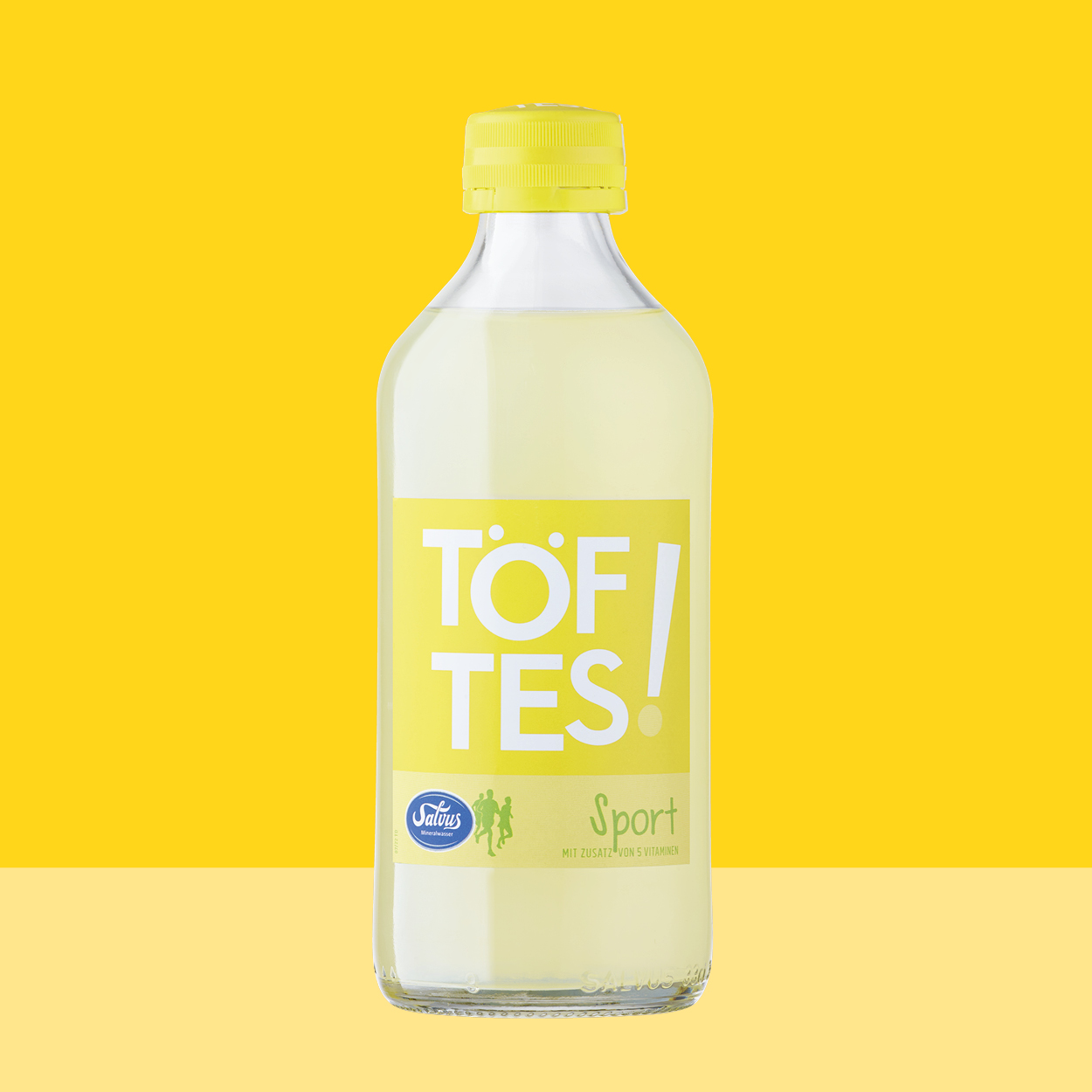 Töftes! Sport Flasche auf gelbem Hintergrund passend zum Etikett.