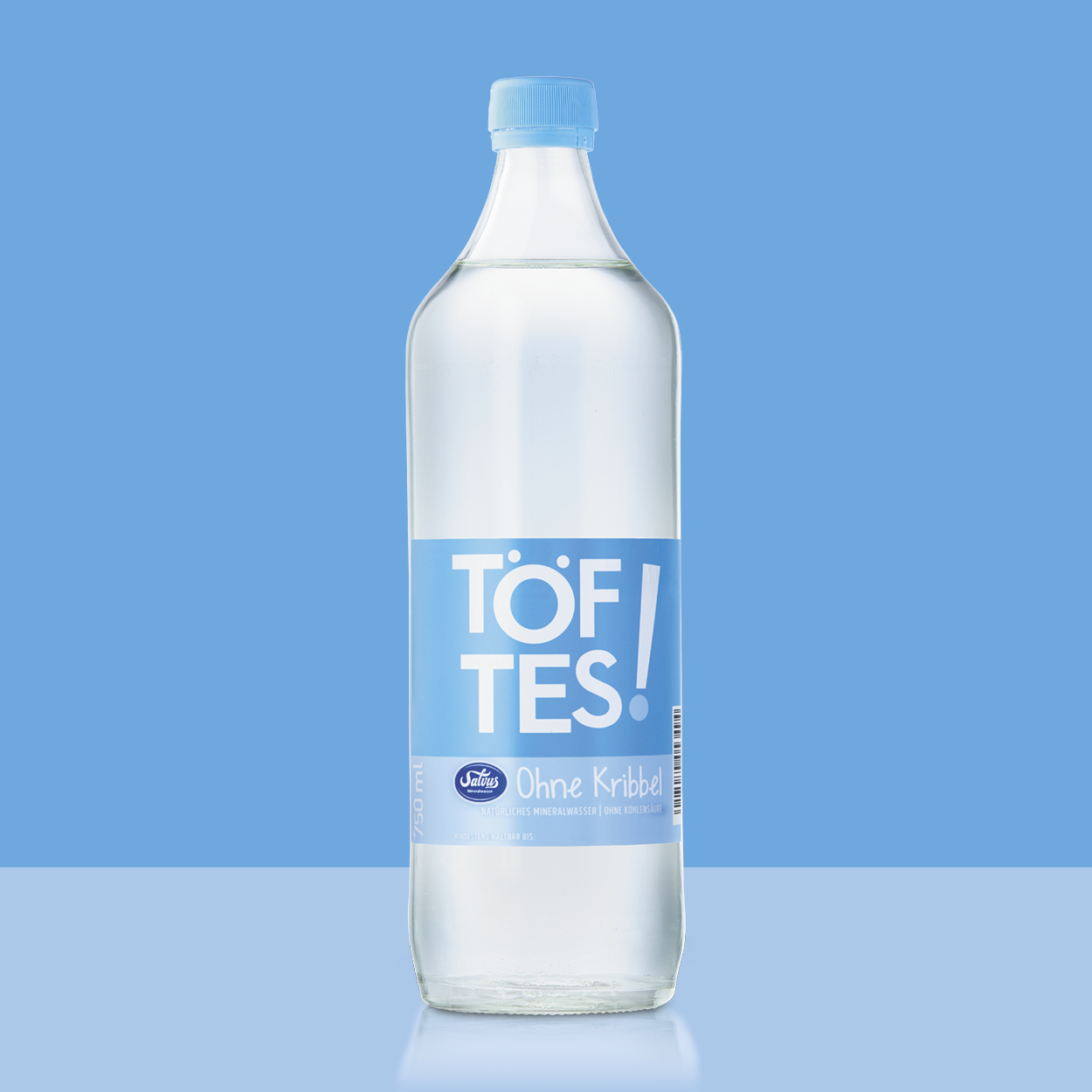 Große Töftes! Ohne Kribbel Flasche auf hellblauem Hintergrund passend zum Etikett.