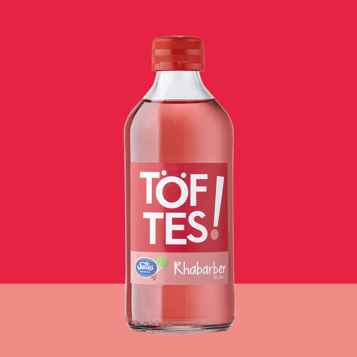 Töftes! Rhabarber Flasche auf rotem Hintergrund passend zum Etikett.