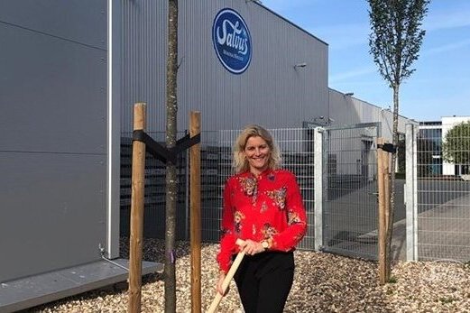 Bild von Heike Schürkötter, wie sie im Rahmen der Einheitsbuddel-Aktion auf dem Salvus-Gelände einen Baum pflanzt.